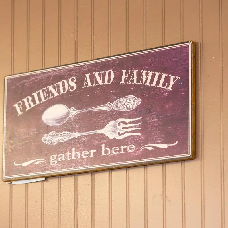 A painted wooden sign that reads Friends and Family gather here