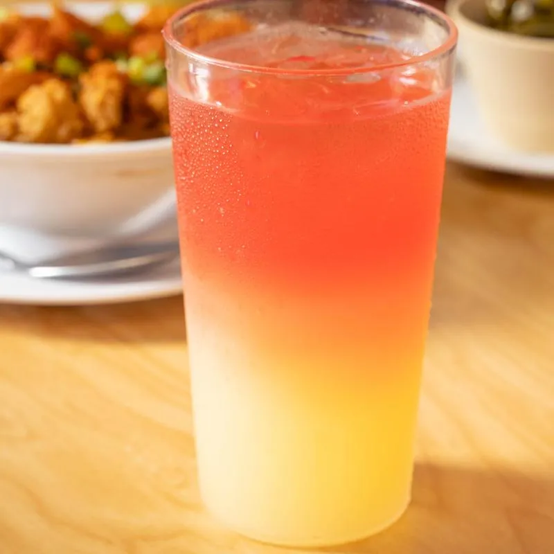 A tall glass of layered fruit punch