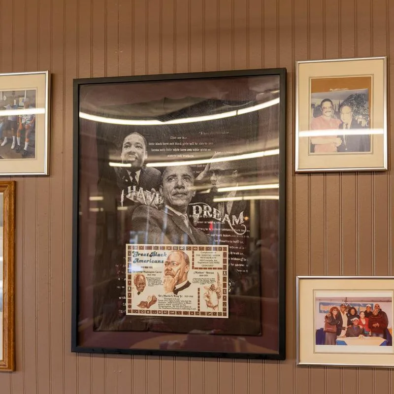 Framed family photos and community keepsakes on a wall inside the restaurant